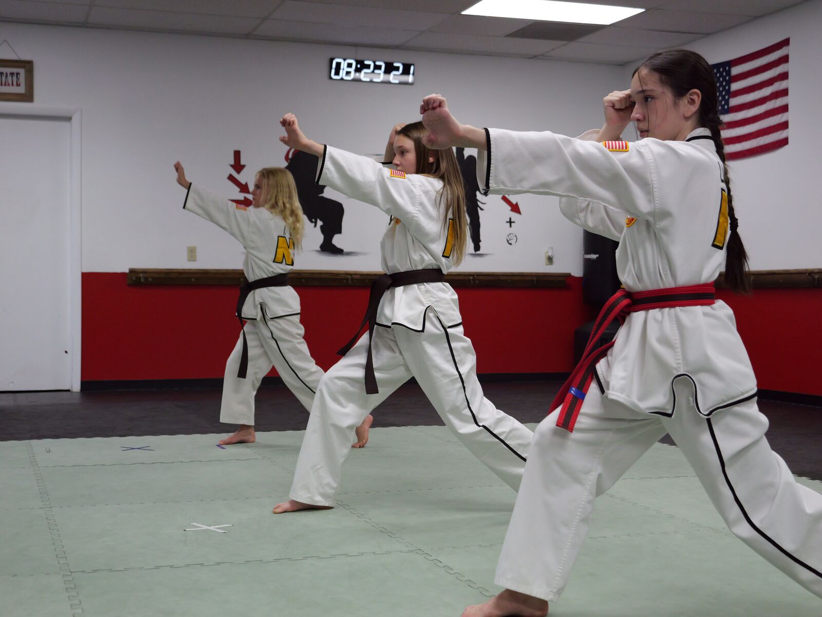 Youth class practicing kicks and blocks in the dojo